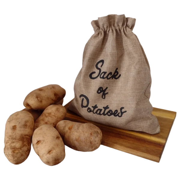 A sack of farm-fresh potatoes on a wooden cutting board